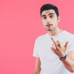 Irritated man showing middle finger isolated on pink