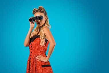 mavi arka plan üzerinde dürbün ile retro tarzı giyim kadın moda PIN yan görünüm