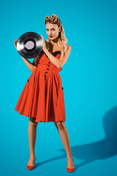青い背景上のビニール レコードと若いピンは ヴィンテージではスタイリッシュな女性のドレスします — ストック写真