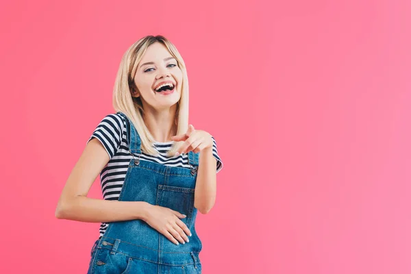 Laughing Girl Denim Overall Pointing Camera Isolated Pink — Stock Photo, Image