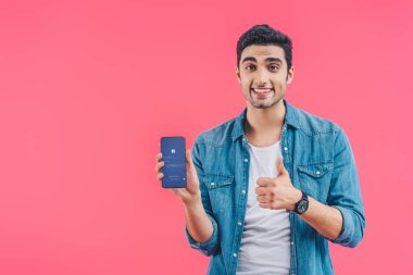 mutlu genç adam yukarı hareket yapıyor ve akıllı telefon pink izole Web sitesi facebook ile gösterilen