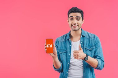yukarı hareket yapıyor ve pink izole meizu smartphone gösterilen mutlu genç adam