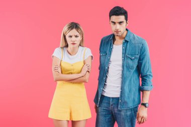 Saldırgan kadın kamera pink izole bakarak kızgın erkek ise çapraz kolları olan ayakta 