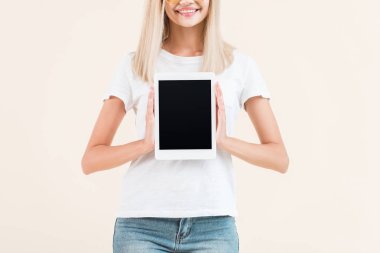 boş ekran üzerinde bej izole ile dijital tablet gösteren gülümseyen genç kadının kısmi görünümü