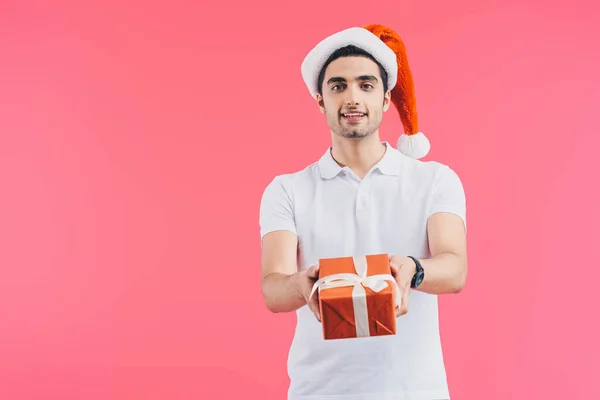 Knappe Man Kerstmuts Geven Geschenkdoos Glimlachend Geïsoleerd Roze Nieuwjaar Concept — Stockfoto