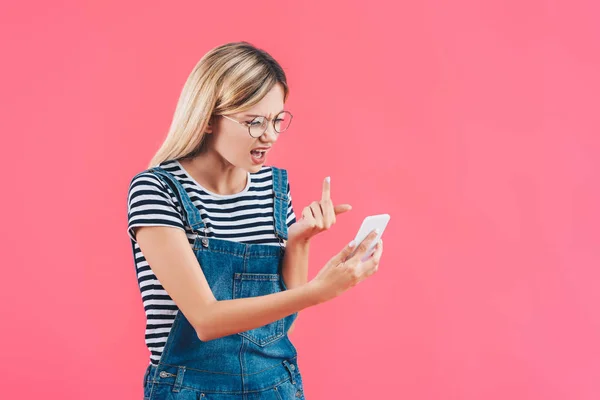 Portret Van Jonge Vrouw Weergegeven Middelvinger Naar Smartphone Geïsoleerd Roze — Gratis stockfoto