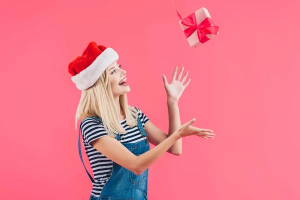 Joven Mujer Santa Claus Sombrero Lanzando Regalo Aislado Rosa — Foto de Stock