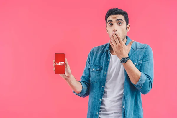 Shocked Young Man Covering Mouth Hand Showing Smartphone Youtube Website — Stock Photo, Image