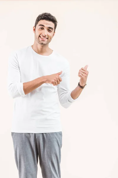 Handsome Young Man Pointing Copy Space Smiling Camera Isolated Beige — Free Stock Photo