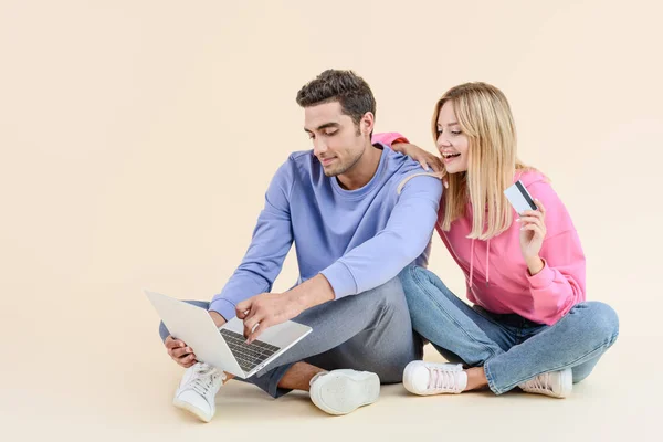 Sorrindo Jovem Casal Com Cartão Crédito Usando Laptop Isolado Bege — Fotografia de Stock