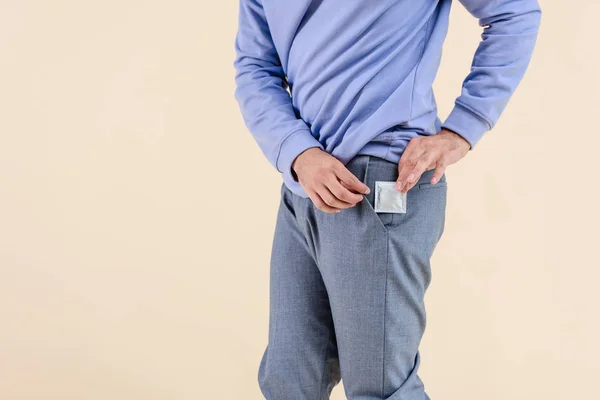 Tiro Cortado Homem Colocando Preservativo Bolso Isolado Bege — Fotografia de Stock