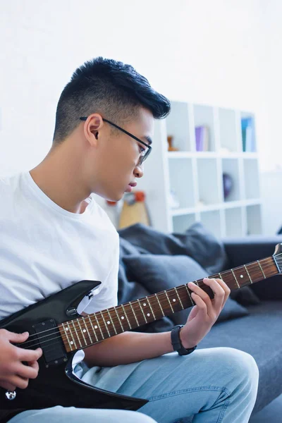 Guapo Asiático Hombre Jugando Eléctrico Guitarra Casa — Foto de stock gratuita