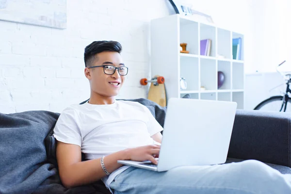 Sorrindo Bonito Asiático Homem Usando Laptop Sofá Casa — Fotografia de Stock