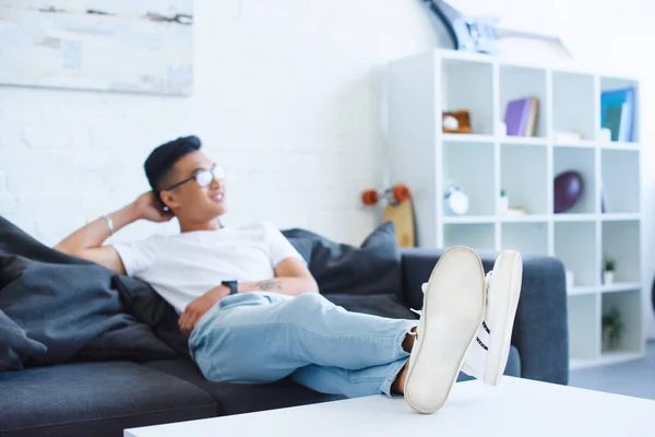 Selective Focus Handsome Asian Man Sitting Sofa Legs Table Home — Free Stock Photo