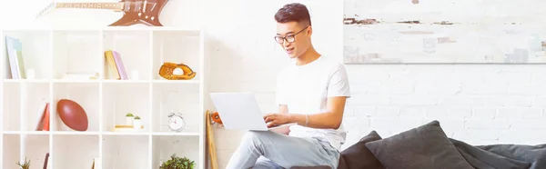 Vista Panorâmica Sorrindo Bonito Asiático Homem Usando Laptop Sofá Sala — Fotografia de Stock