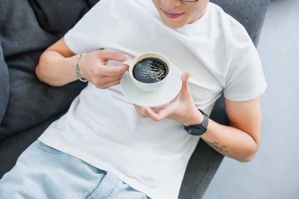 Beskuren Bild Ung Man Hålla Kopp Kaffe Medan Vilar Soffan — Stockfoto