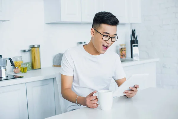 Cheerful Young Asian Man Eyeglasses Using Digital Tablet — Free Stock Photo