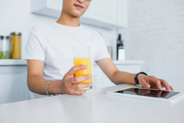 Recortado Disparo Joven Sosteniendo Vaso Jugo Utilizando Tableta Digital — Foto de Stock