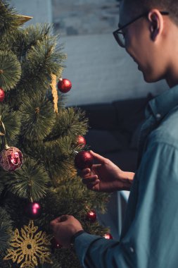 Asyalı gencin Noel ağacı evde dekorasyon gözlük içinde kırpılmış atış