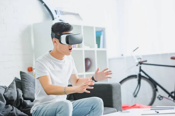 Emocional Jovem Asiático Homem Sentado Sofá Usando Realidade Virtual Headset — Fotografia de Stock