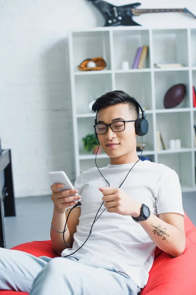 Красивий Молодий Азіатський Чоловік Використовує Смартфон Слухає Музику Навушниках — Безкоштовне стокове фото