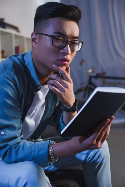 Enfocado Joven Asiático Hombre Gafas Lectura Libro Casa — Foto de stock gratis