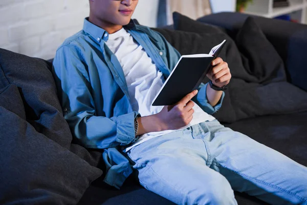 Tiro Cortado Jovem Sentado Sofá Livro Leitura — Fotografia de Stock