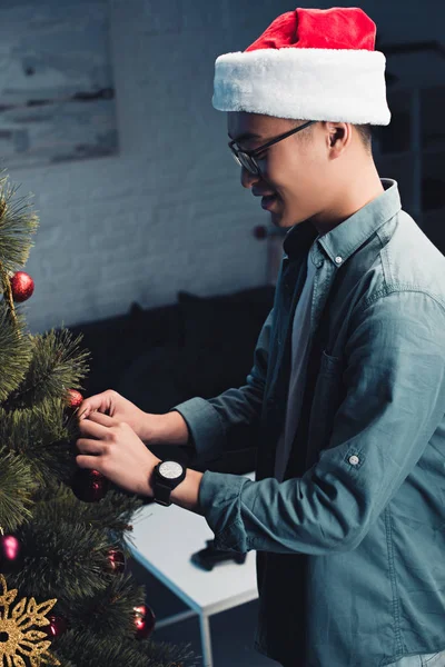 Boční Pohled Usmívající Mladý Asiat Santa Klobouk Dekorační Vánoční Stromeček — Stock fotografie zdarma