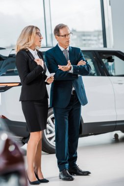 iş adamı ve iş kadını ile smartphone yeni otomobil showroom seçme