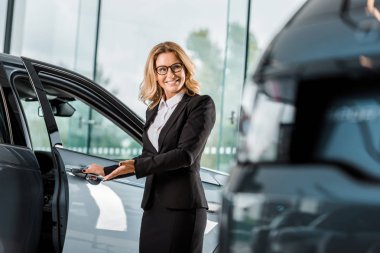 çekici gülümseyen kadın araba satıcısı açılış araba showroom