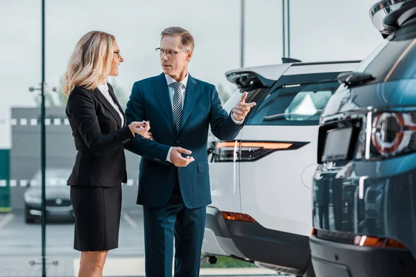 Hombre Negocios Mujer Negocios Elegir Nuevo Automóvil Sala Exposición — Foto de Stock