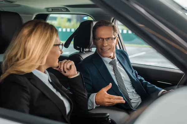 Lachende Business Paar Zittend Nieuwe Auto Voor Test Drive — Gratis stockfoto