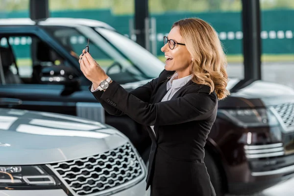 Glad Affärskvinna Högtidskläder Håller Bilnyckel Från Bil Återförsäljaravtalet Salong — Gratis stockfoto