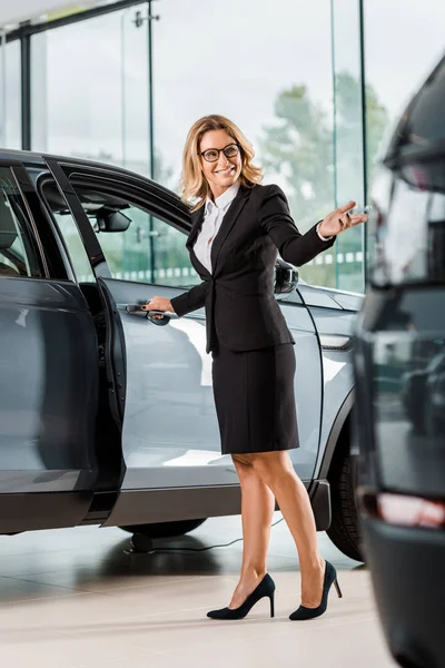 Happy Female Car Dealer Opening Car Showroom — Stock Photo, Image