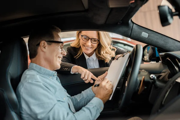 Adult Man Signing Contract Female Car Dealer While Sitting Car — Stock Photo, Image