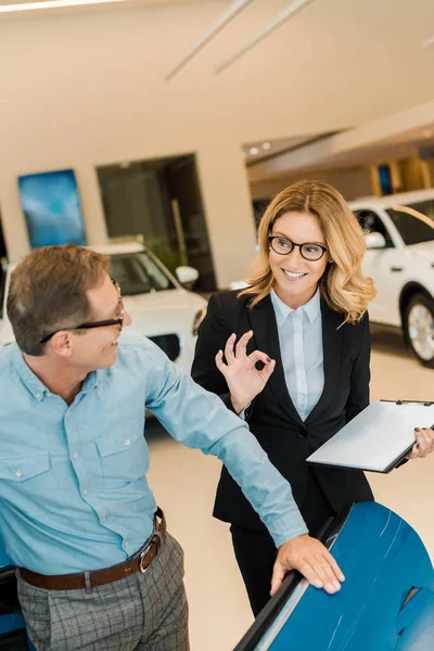 Adult Man Checking Luxury Sport Car Female Car Dealer Showroom — Stock Photo, Image