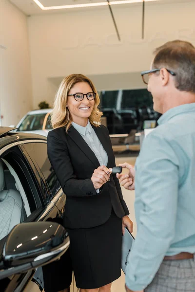Adult Man Taking Car Key Female Car Dealer Showroom — Free Stock Photo