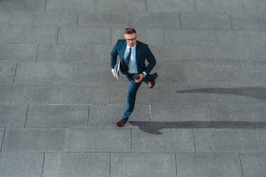 işadamı kahve tutarak ve sokakta çalışan resmi aşınmaya yüksek açı görünümünü orta yaşlı