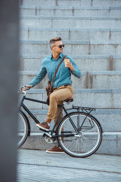 Hombre Elegante Auriculares Gafas Sol Sosteniendo Taza Papel Bicicleta Montar —  Fotos de Stock