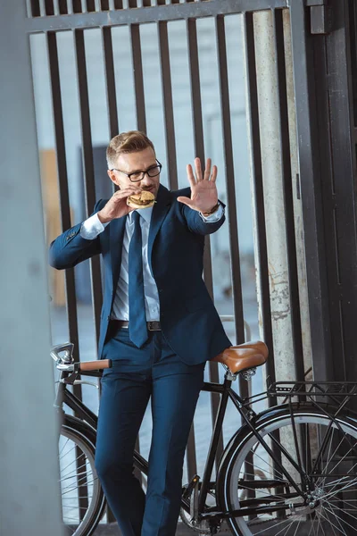 Homem Negócios Meia Idade Gesticular Mão Enquanto Sentado Bicicleta Comer — Fotos gratuitas