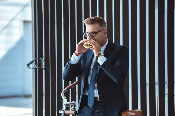 Middle Aged Businessman Sitting Bicycle Eating Hamburger — Stock Photo, Image