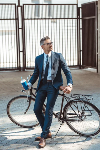 Bonito Sorridente Empresário Segurando Copo Papel Sentado Bicicleta Rua — Fotografia de Stock