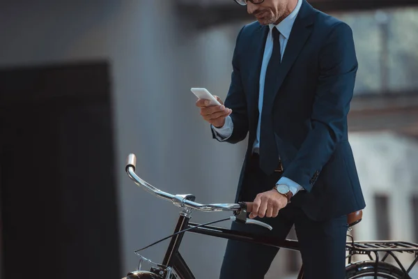 Обрезанный Снимок Бизнесмена Сидящего Велосипеде Использующего Смартфон — стоковое фото