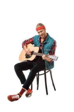 Akustik gitar üzerinde beyaz izole çalmaya denim yelek erkekte mutlu hippi