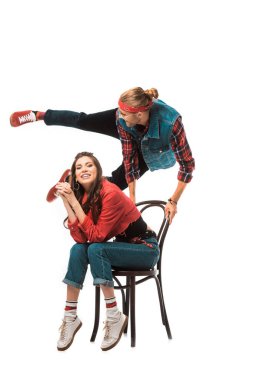 hipster sevgilisini arkasında atlama üzerinde beyaz izole iken sandalyede oturan güzel mutlu kadın 
