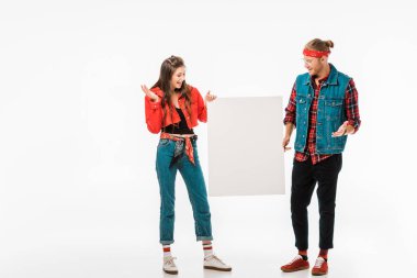 boş tutan şık hipster çift afiş ve üzerinde beyaz izole omuz silkme hareketi yapıyor