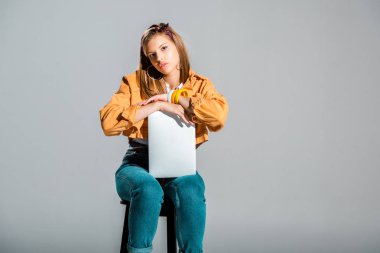 gri izole dışkı oturan dizüstü bilgisayar ile sıkılmış kız