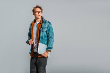 yakışıklı şık erkek hipster gri izole dizüstü bilgisayar ile poz