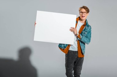 heyecanlı erkek hipster boş afişini gri holding