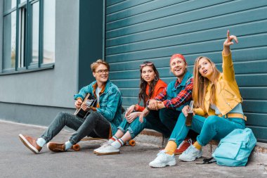 Akustik gitar ve bir yere işaret kız oynayan adam sokakta birlikte vakit hipsters 